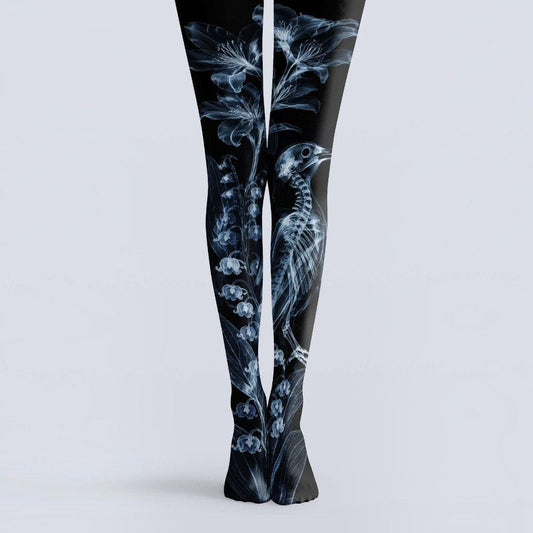 Avaeri black tights are printed with white X-ray-style patterns of flowers and bird skeletons, crafted from comfortable stretch fabric to showcase a dark romantic aesthetic.